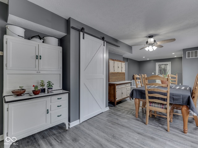 730 N Forsythe St, Franklin, IN 46131 - dining space with a barn door, a ceiling fan, light wood finished floors, a textured ceiling, and recessed lighting