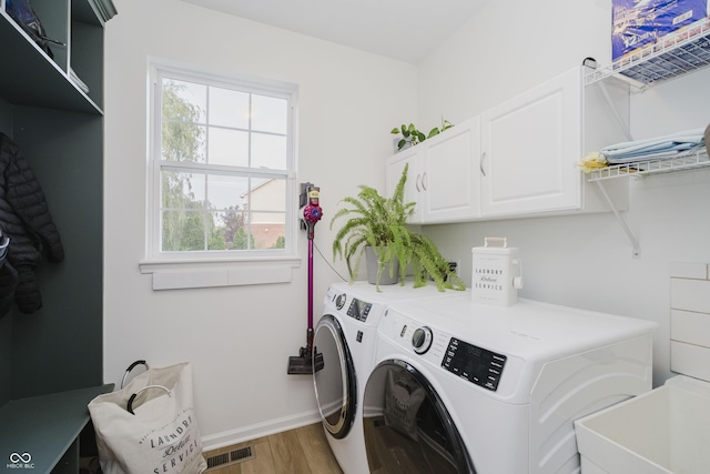 3876 Kegler Way, Carmel, IN 46074 - laundry room featuring washer and clothes dryer, light wood-style flooring, cabinet space, and healthy amount of natural light