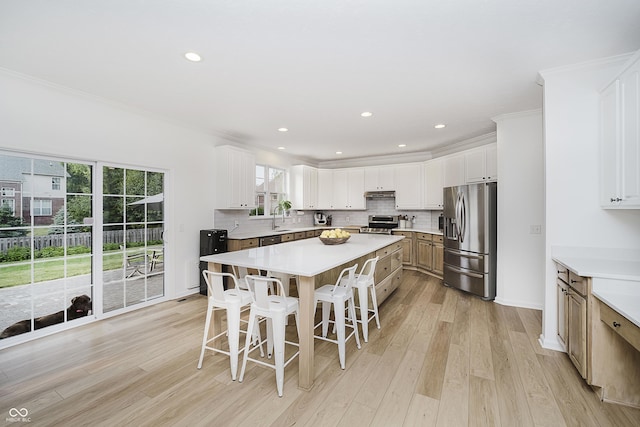 3876 Kegler Way, Carmel, IN 46074 - kitchen featuring stainless steel appliances, a sink, a breakfast bar area, plenty of natural light, and crown molding