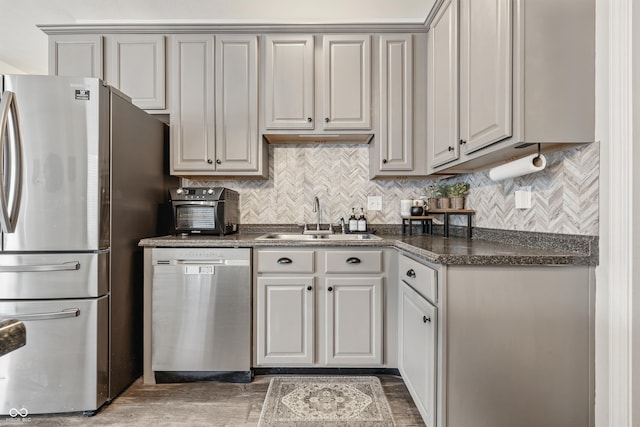 5030 E 800 N, Columbus, IN 47203 - kitchen with stainless steel appliances, a sink, dark countertops, wood finished floors, and decorative backsplash