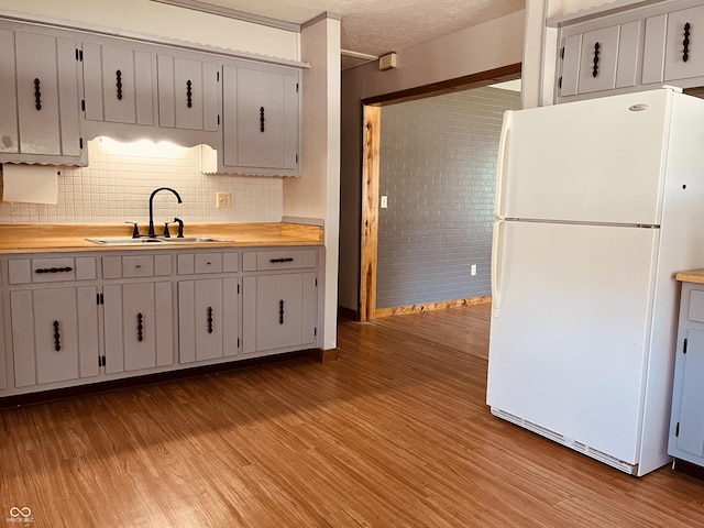 514 W 6th St, Sheridan, IN 46069 - kitchen featuring freestanding refrigerator, a sink, light wood-style floors, light countertops, and decorative backsplash