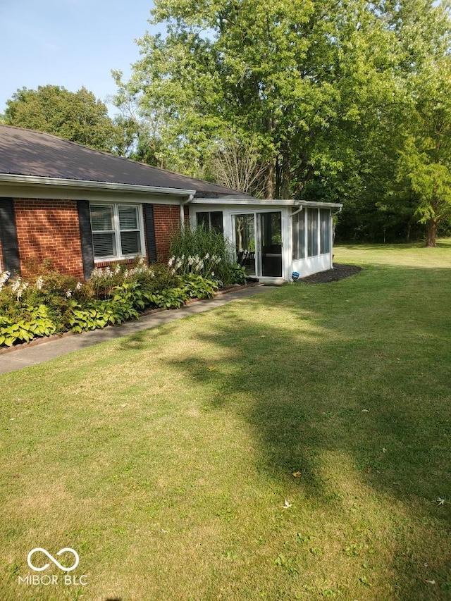 1322 Greenway Dr, Anderson, IN 46011 - view of front of home with brick siding, a sunroom, and a front yard
