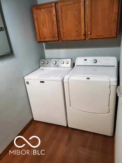 1322 Greenway Dr, Anderson, IN 46011 - laundry area with washer and clothes dryer, cabinet space, wood finished floors, and baseboards