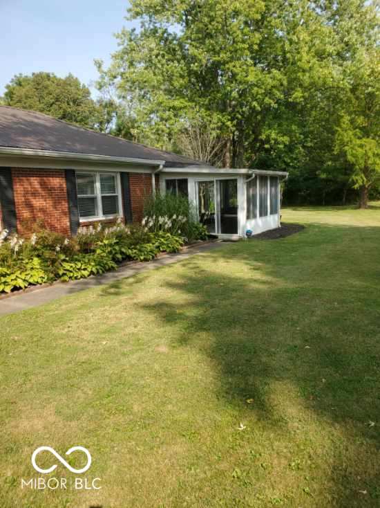 1322 Greenway Dr, Anderson, IN 46011 - view of front facade featuring a sunroom, brick siding, and a front lawn