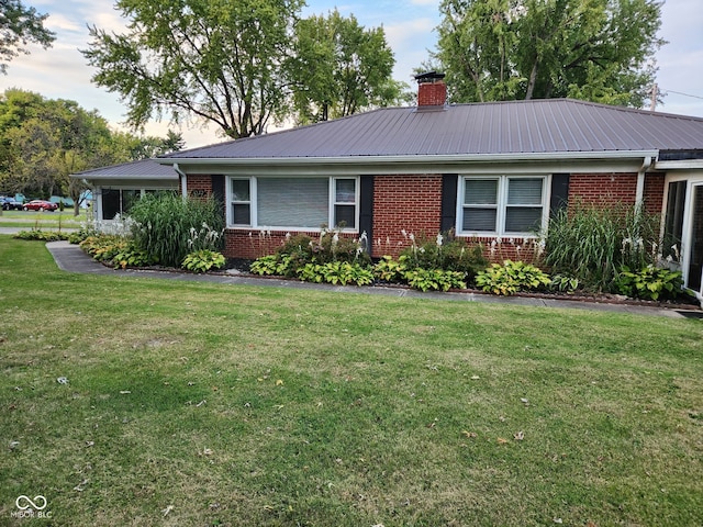 1322 Greenway Dr, Anderson, IN 46011 - ranch-style house featuring brick siding, metal roof, a front lawn, and a chimney