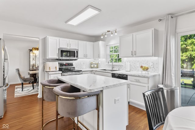2326 Gradison Cir, Indianapolis, IN 46214 - kitchen with stainless steel appliances, a sink, a kitchen bar, and white cabinets