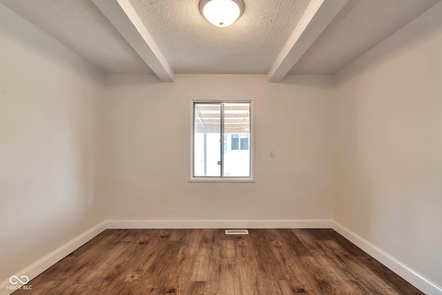 3242 Welch Dr, Indianapolis, IN 46224 - empty room with beam ceiling, dark wood-style floors, baseboards, and a textured ceiling