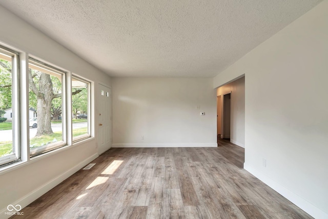 3242 Welch Dr, Indianapolis, IN 46224 - spare room featuring a textured ceiling, wood finished floors, and baseboards