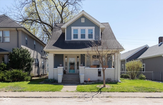 831 Weghorst St, Indianapolis, IN 46203 - view of front of house with a porch, brick siding, and roof with shingles