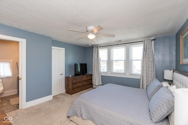831 Weghorst St, Indianapolis, IN 46203 - bedroom featuring ceiling fan, light carpet, baseboards, connected bathroom, and a textured ceiling