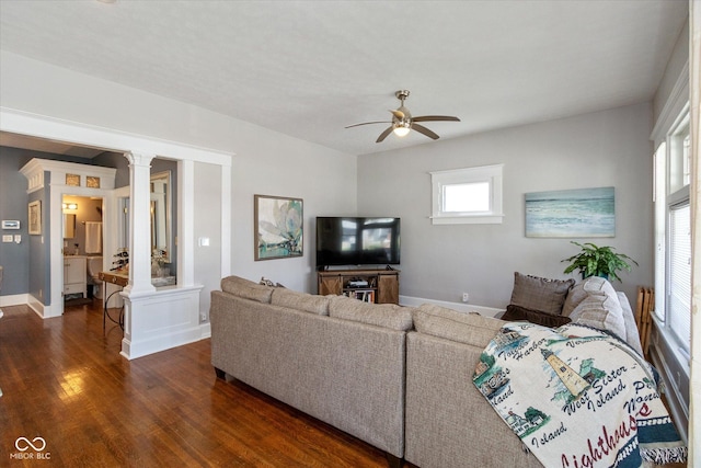 831 Weghorst St, Indianapolis, IN 46203 - living room featuring dark wood-style floors, a ceiling fan, baseboards, and ornate columns