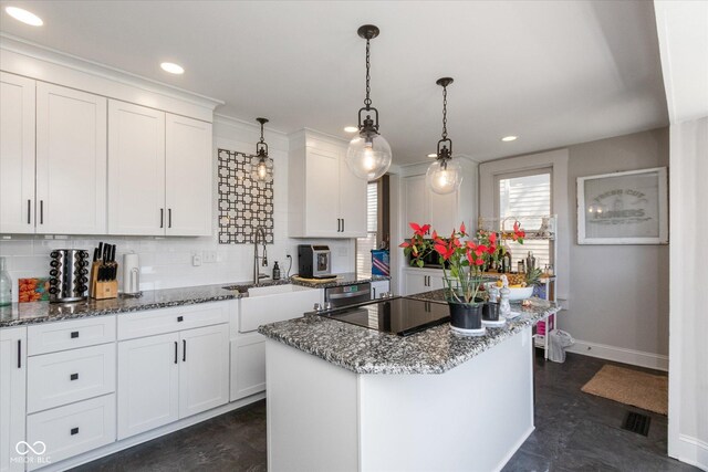 831 Weghorst St, Indianapolis, IN 46203 - kitchen with baseboards, white cabinets, decorative backsplash, black electric cooktop, and a kitchen island