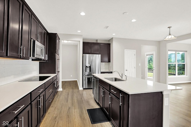 6762 Brentwood Ct, Brownsburg, IN 46112 - kitchen featuring a sink, black appliances, decorative backsplash, light wood-style floors, and recessed lighting