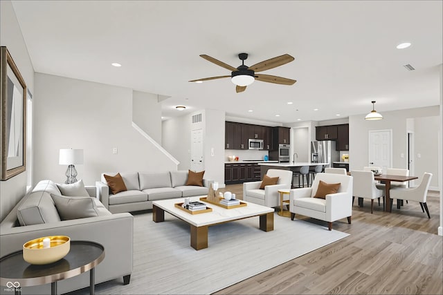 6762 Brentwood Ct, Brownsburg, IN 46112 - living room with light wood-type flooring, a ceiling fan, and recessed lighting