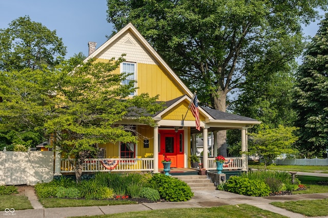 224 N Pennsylvania St, Greenfield, IN 46140 - view of front of home featuring a porch, a chimney, and board and batten siding
