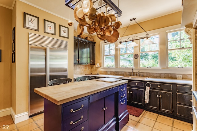 224 N Pennsylvania St, Greenfield, IN 46140 - kitchen with built in fridge, a sink, ornamental molding, wooden counters, and light tile patterned floors