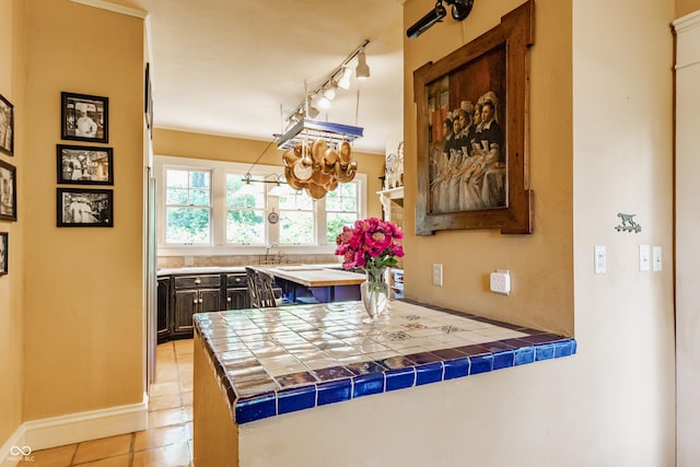 224 N Pennsylvania St, Greenfield, IN 46140 - kitchen featuring a peninsula, light tile patterned floors, a chandelier, tile counters, and rail lighting