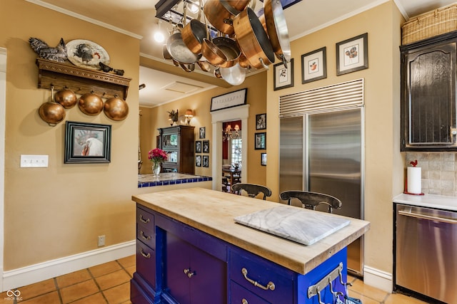 224 N Pennsylvania St, Greenfield, IN 46140 - kitchen featuring appliances with stainless steel finishes, butcher block countertops, blue cabinetry, a chandelier, and ornamental molding