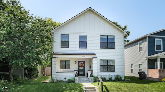 615 Orange St, Indianapolis, IN 46203 - view of front of property featuring board and batten siding, a front yard, and brick siding