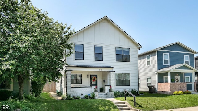 615 Orange St, Indianapolis, IN 46203 - view of front facade featuring board and batten siding and a front lawn