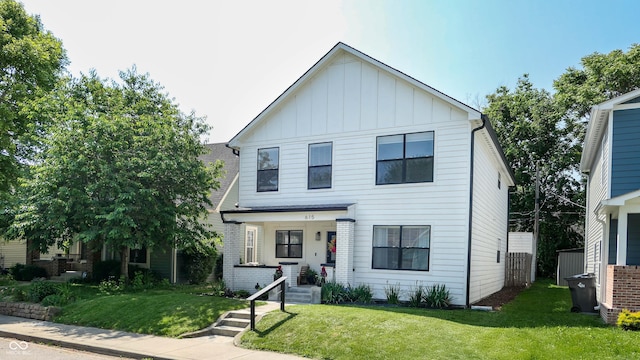 615 Orange St, Indianapolis, IN 46203 - view of front facade with board and batten siding and a front lawn