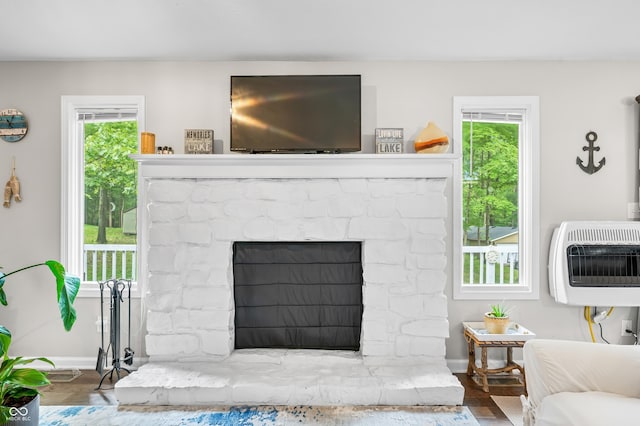 6933 Grey Wolf Dr, Hamblen Township, IN 46164 - living room featuring heating unit, a stone fireplace, baseboards, and plenty of natural light