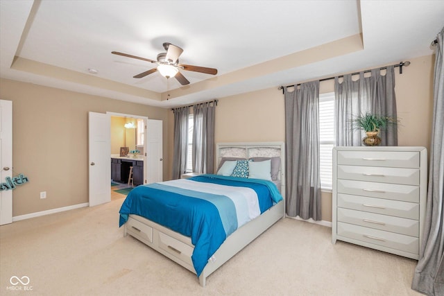 5767 Bluff View Ln, Whitestown, IN 46075 - bedroom featuring a raised ceiling, light carpet, baseboards, ensuite bath, and ceiling fan