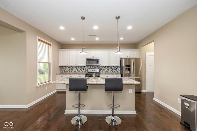 5767 Bluff View Ln, Whitestown, IN 46075 - kitchen with stainless steel appliances, a center island with sink, white cabinets, decorative backsplash, and recessed lighting