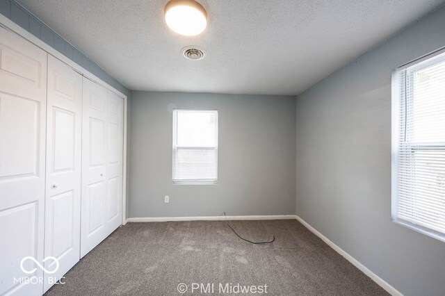 5050 W Regent St, Indianapolis, IN 46241 - unfurnished bedroom featuring carpet flooring, a closet, baseboards, and a textured ceiling