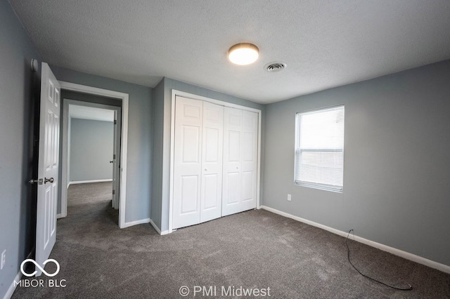 5050 W Regent St, Indianapolis, IN 46241 - unfurnished bedroom with dark colored carpet, baseboards, a closet, and a textured ceiling