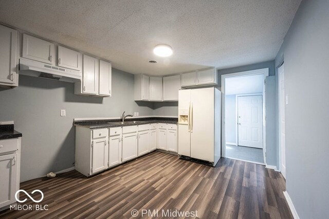 5050 W Regent St, Indianapolis, IN 46241 - kitchen featuring white fridge with ice dispenser, a sink, under cabinet range hood, dark wood finished floors, and dark countertops