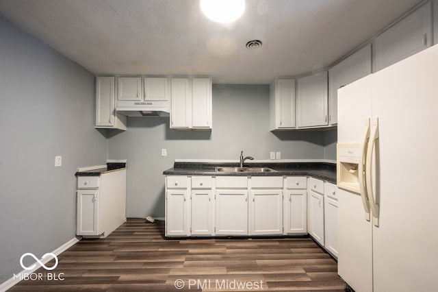 5050 W Regent St, Indianapolis, IN 46241 - kitchen with white refrigerator with ice dispenser, a sink, under cabinet range hood, dark wood-style flooring, and dark countertops