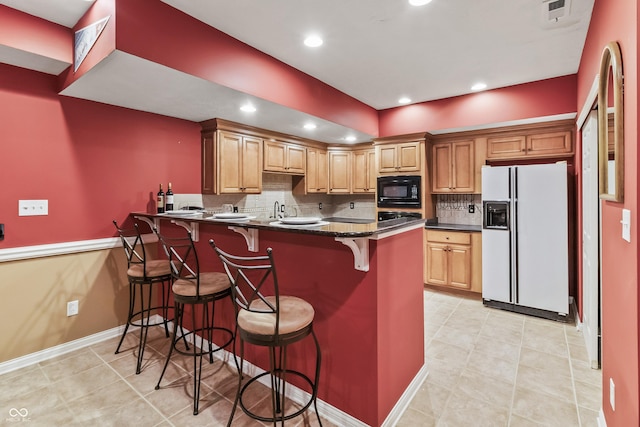 8663 N Commonview Dr, Mccordsville, IN 46055 - kitchen with white fridge with ice dispenser, black microwave, a peninsula, a breakfast bar area, and tasteful backsplash