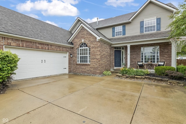 8663 N Commonview Dr, Mccordsville, IN 46055 - traditional-style house with brick siding, driveway, a shingled roof, an attached garage, and a porch
