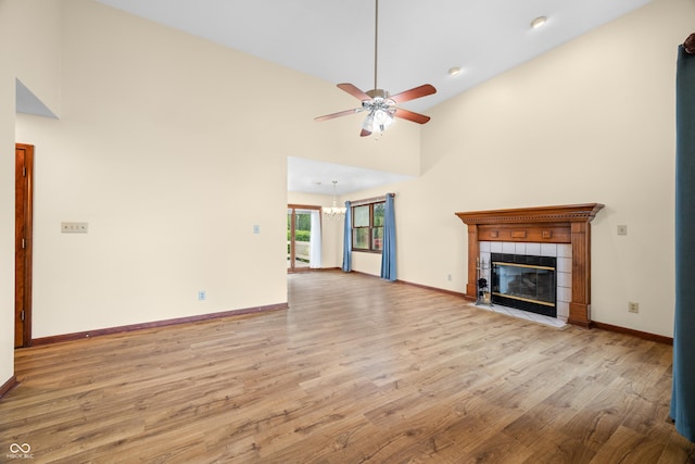 1105 Sarah Ct, Greenwood, IN 46142 - unfurnished living room featuring wood finished floors, a ceiling fan, a fireplace, baseboards, and high vaulted ceiling