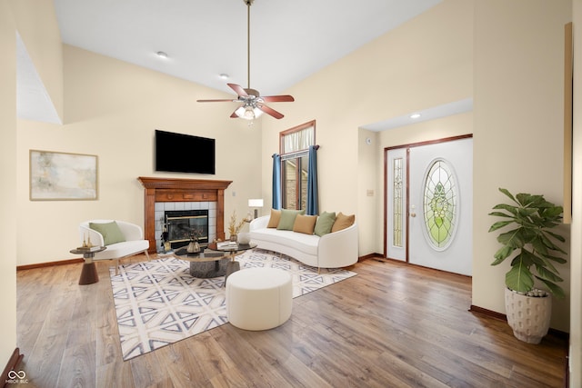 1105 Sarah Ct, Greenwood, IN 46142 - living area featuring wood finished floors, a tiled fireplace, healthy amount of natural light, baseboards, and a towering ceiling