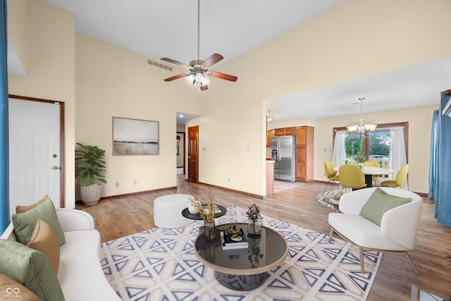 1105 Sarah Ct, Greenwood, IN 46142 - living room with a chandelier, light wood finished floors, a ceiling fan, high vaulted ceiling, and baseboards