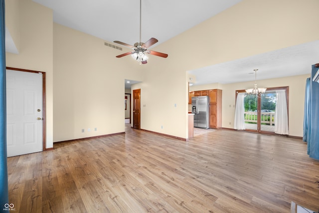 1105 Sarah Ct, Greenwood, IN 46142 - unfurnished living room featuring a chandelier, light wood-style floors, ceiling fan, a high ceiling, and baseboards