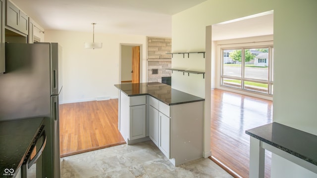 1460 W Mckay Rd, Shelbyville, IN 46176 - kitchen featuring freestanding refrigerator, dark countertops, decorative light fixtures, baseboards, and light wood-type flooring