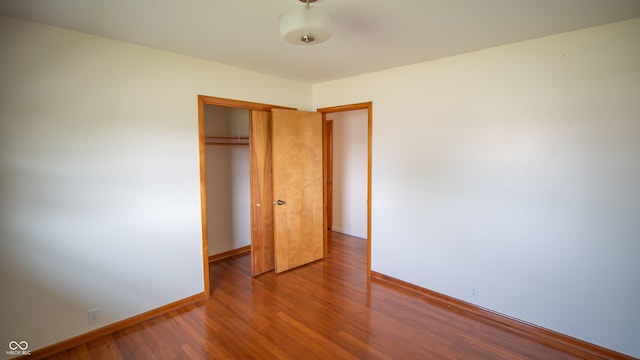 1460 W Mckay Rd, Shelbyville, IN 46176 - unfurnished bedroom featuring a closet, wood finished floors, and baseboards