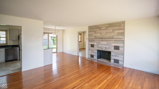 1460 W Mckay Rd, Shelbyville, IN 46176 - unfurnished living room featuring light wood-style flooring, a fireplace, and baseboards