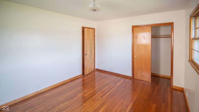 1460 W Mckay Rd, Shelbyville, IN 46176 - unfurnished bedroom featuring wood finished floors, a closet, and baseboards