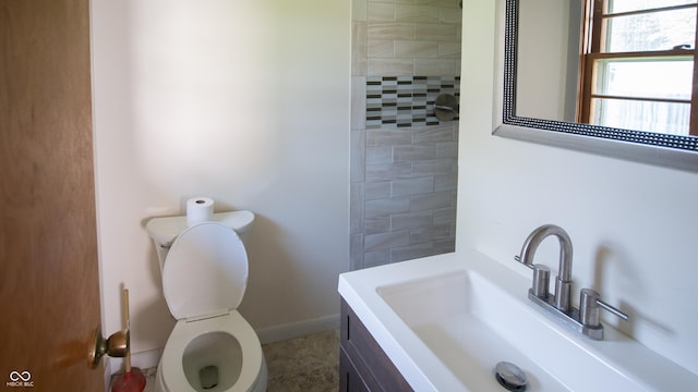 1460 W Mckay Rd, Shelbyville, IN 46176 - bathroom featuring toilet, vanity, baseboards, and a tile shower