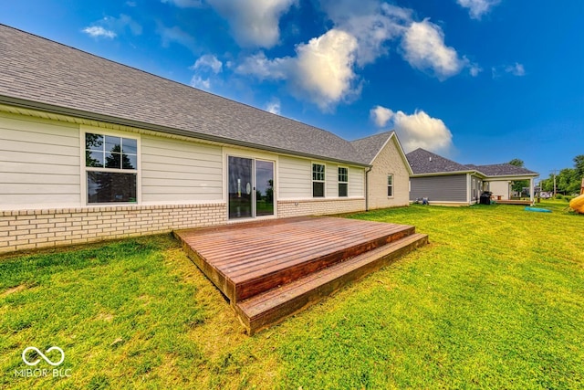 32 Downing Dr, Trafalgar, IN 46181 - back of property featuring brick siding, a lawn, a wooden deck, and roof with shingles