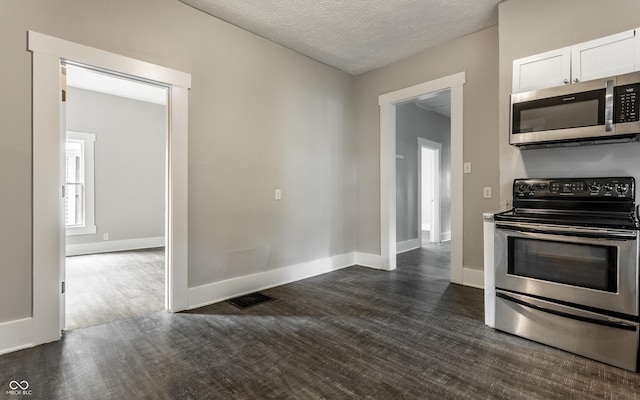 3652 N Kenwood Ave, Indianapolis, IN 46208 - kitchen featuring appliances with stainless steel finishes, dark wood-style flooring, white cabinets, baseboards, and a textured ceiling
