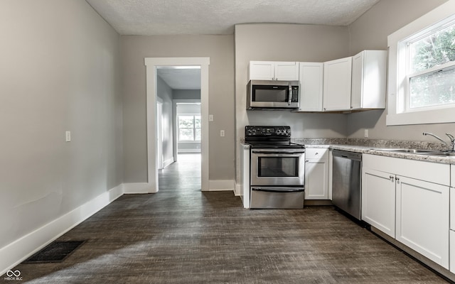 3652 N Kenwood Ave, Indianapolis, IN 46208 - kitchen with appliances with stainless steel finishes, a sink, white cabinets, dark wood-style floors, and a textured ceiling
