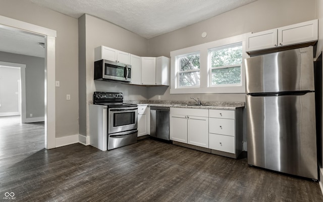 3652 N Kenwood Ave, Indianapolis, IN 46208 - kitchen with appliances with stainless steel finishes, white cabinets, dark wood-type flooring, a sink, and a textured ceiling