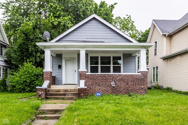 3652 N Kenwood Ave, Indianapolis, IN 46208 - view of front of house featuring a porch, a front lawn, and brick siding