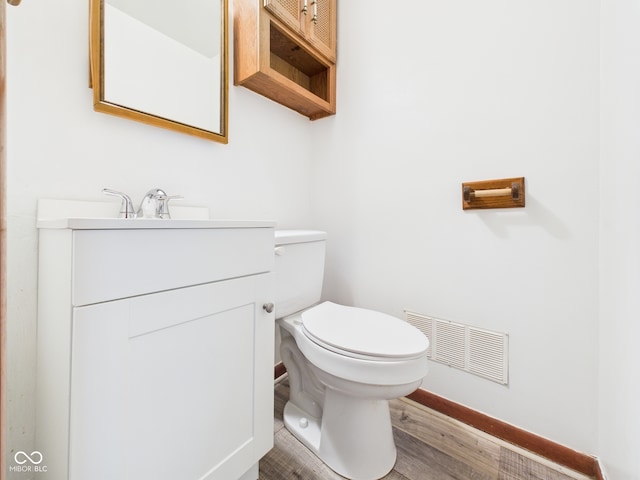 4733 E 100 S, Anderson, IN 46017 - half bathroom featuring toilet, baseboards, vanity, and wood finished floors