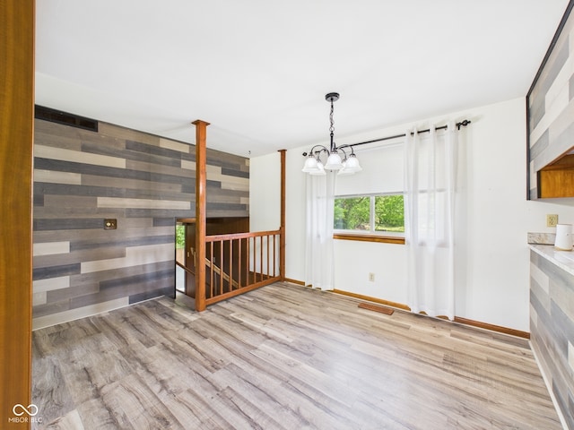 4733 E 100 S, Anderson, IN 46017 - unfurnished room with wood finished floors, a chandelier, baseboards, and wooden walls